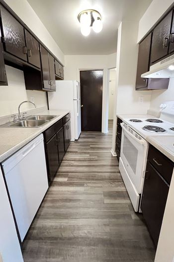 An empty kitchen with white appliances and black and white cabinets